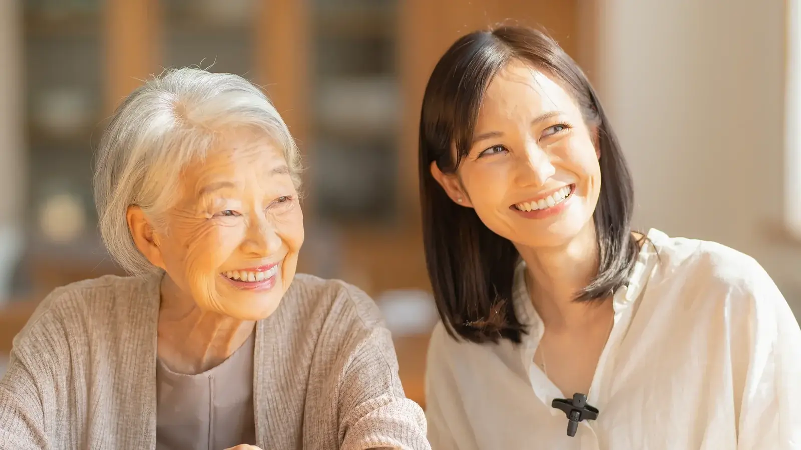 胸元にワイヤレスマイクを着けた娘さんと、笑顔で会話するお母さま